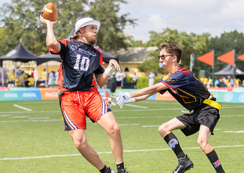 Two Special Olympics athletes are on a flag football field. 