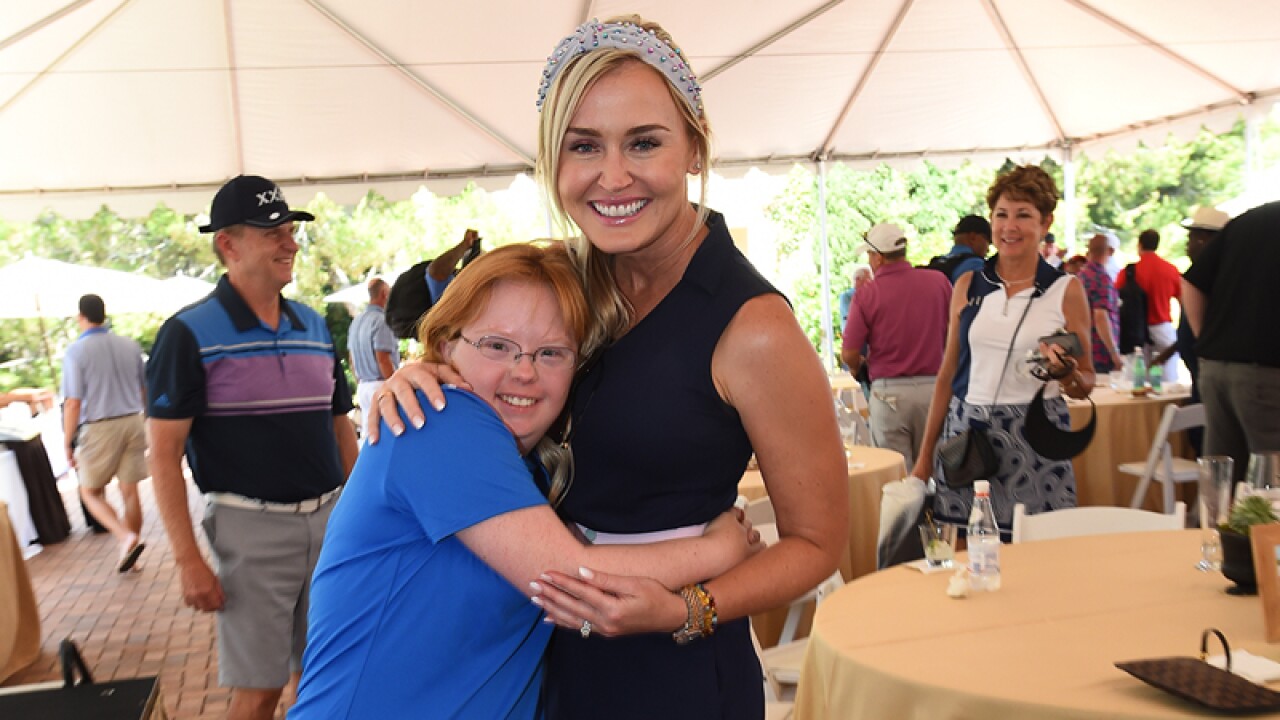 Amy hugs and shares her joy with celebrity golfer.