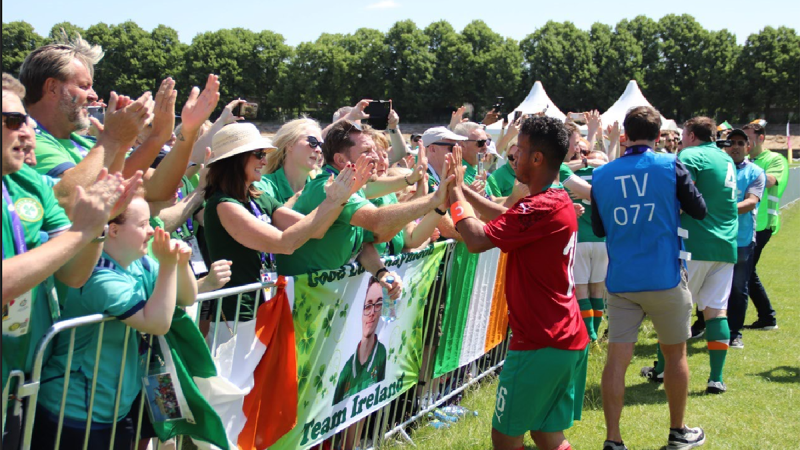 Irish man high-fiving SO Morocco player with fans surrounding them