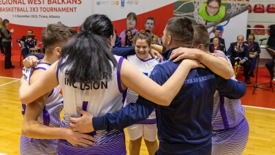 A team of 7 people wearing blue jerseys hugging and jumping