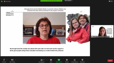 A screenshot of a Zoom meeting featuring a woman in a red t-shirt facing the camera, a photo of the woman with a younger woman.