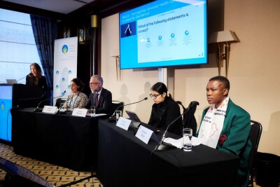 Special Olympics Zimbabwe Health Messenger Barbara Njovo sits among other speakers at a table.