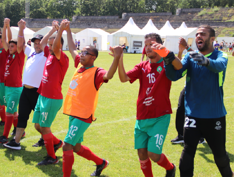 Men side by side holding hands with their arms raised over their heads