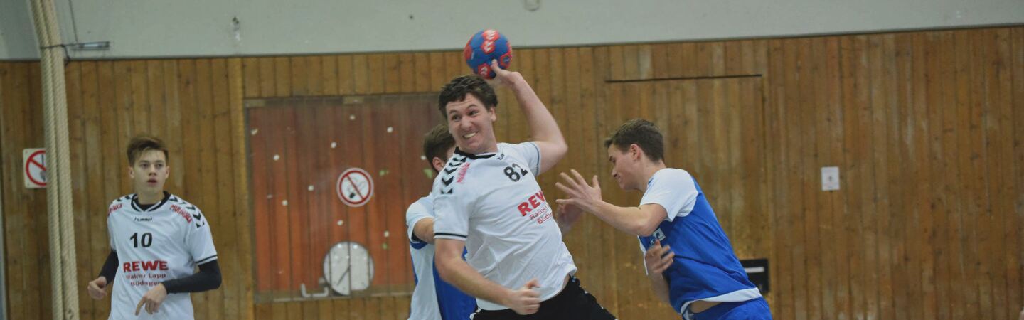 Player prepares to throw the ball while two players from the opposing team attempt to block. 