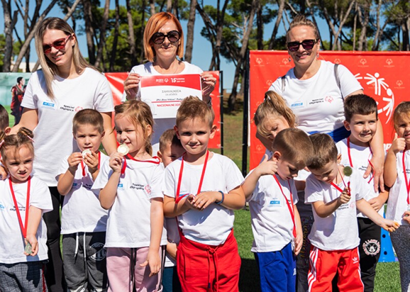 Zana (second from left) and Biljana (right) stand with students. 