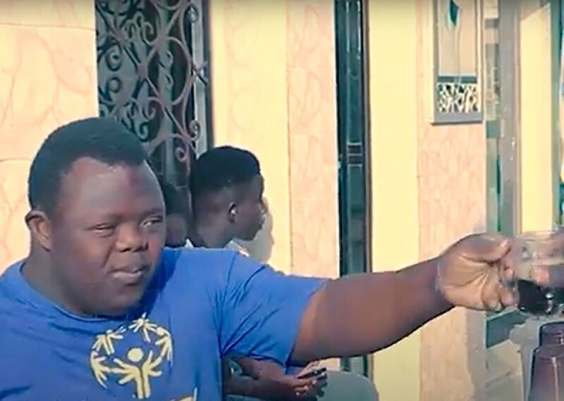 Young man handing a cup of coffee to someone. 