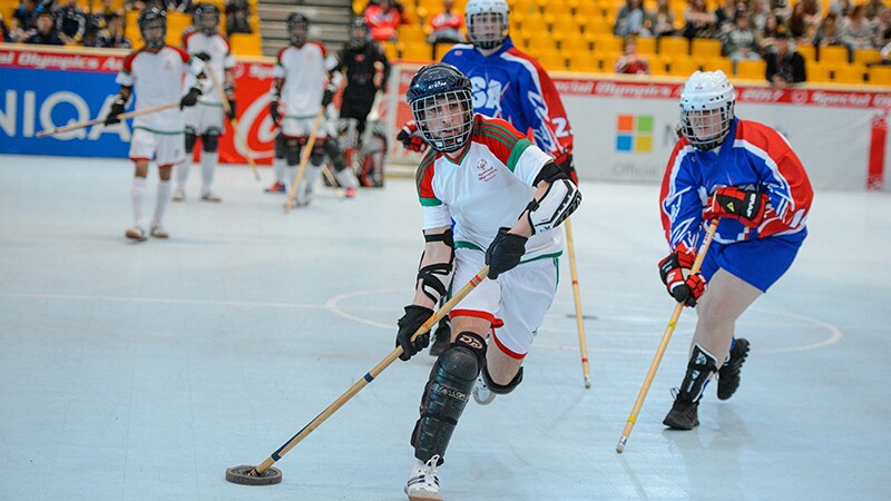 Floor hockey players in the middle of a game. 