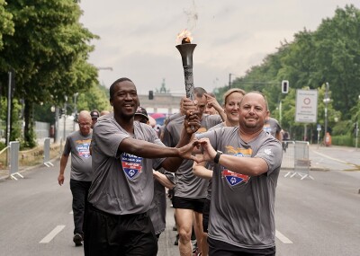 Law enforcement members are running with the torch through a city. 