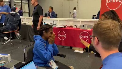 Young woman covering her mouth and nose in emotion; it's the first time she is able to hear. 