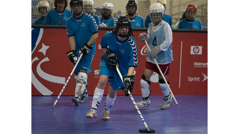 Three floor hockey players during a game. 