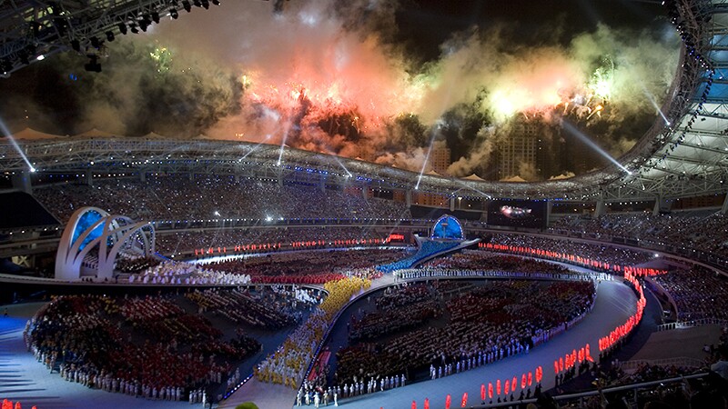 Opening ceremony with fireworks and light show in a large stadium. 