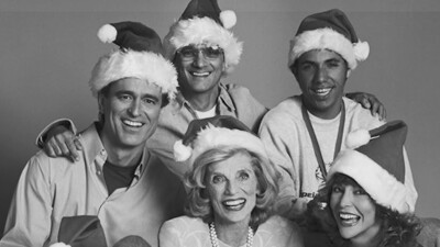 A Very Special Christmas sponsors and singers in a group wearing Santa hats. 