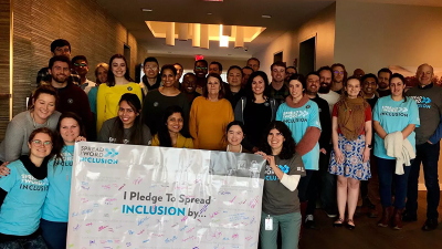 A group of people stand with a Spread the Word banner. 