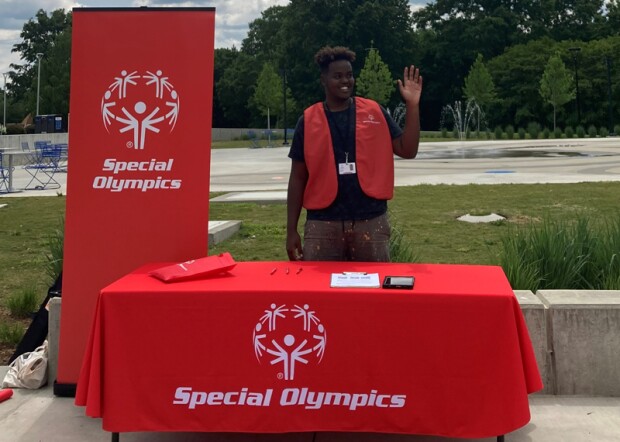 A canvasser standing at a table with Special Olympics branding.