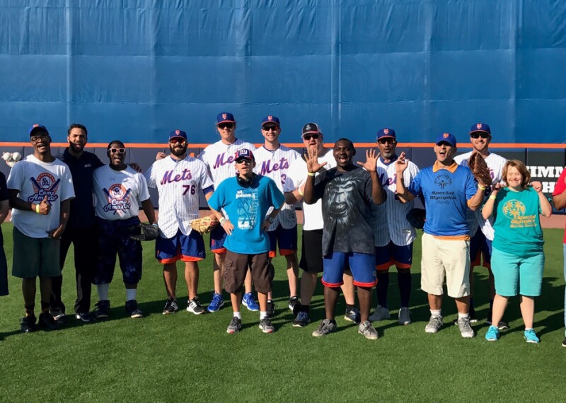 Group of New York Mets players and SO athletes on the field for a group photo. 