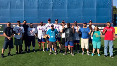 Group of New York Mets players and SO athletes on the field for a group photo. 