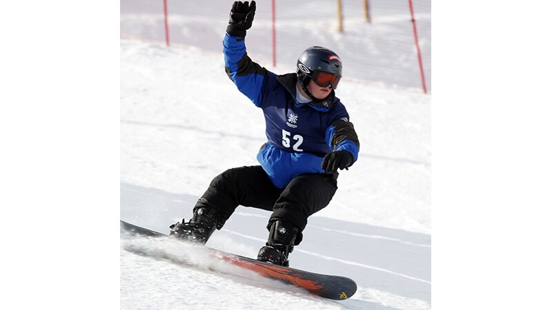 A snowboarder going down the hill