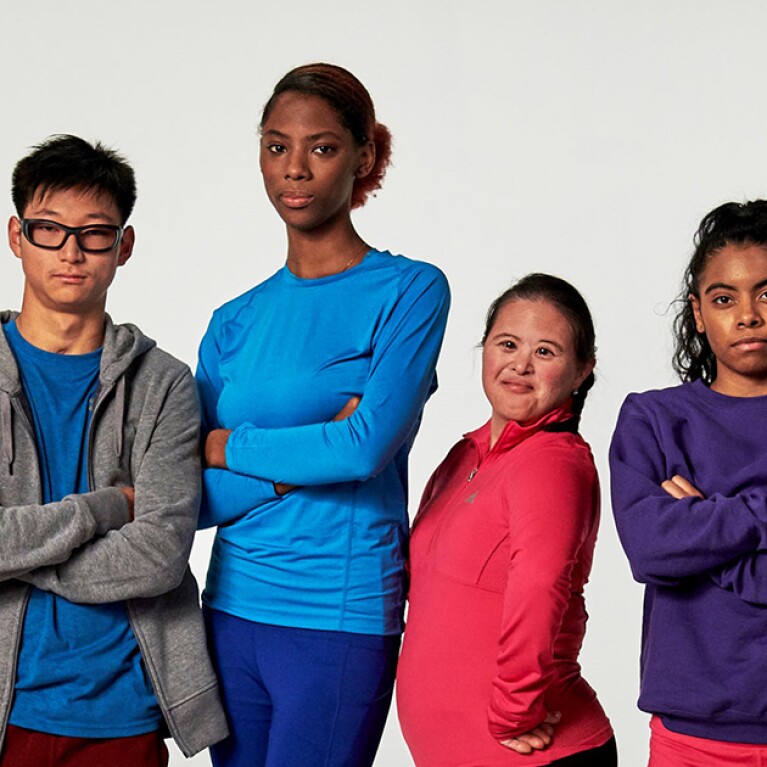 Group of seven young adults standing side by side for a group photo. 