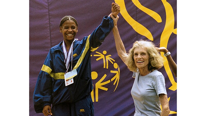 Eunice Kennedy Shriver celebrates with Loretta Clairborne, holding her had up in victory. 