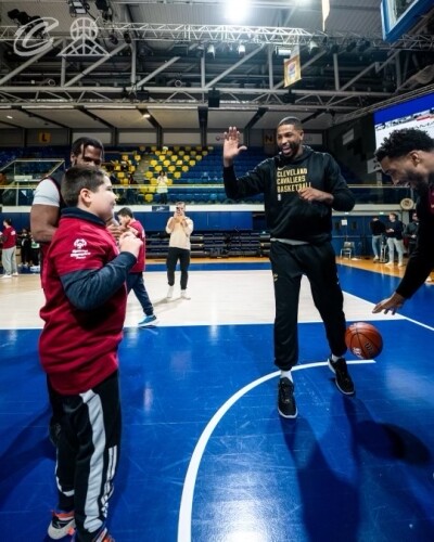 Tristan Thompson walks on a court to give a high-five to a young Special Olympics athlete