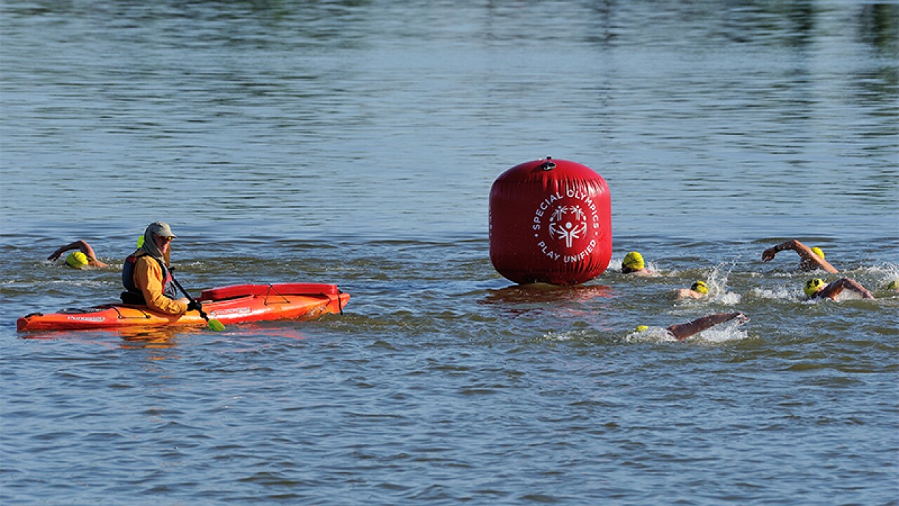 Lifeboats patrol the river and the safety of athletes in the open water as the swimmers round a Special Olympics Play Unified themed Buoy. 