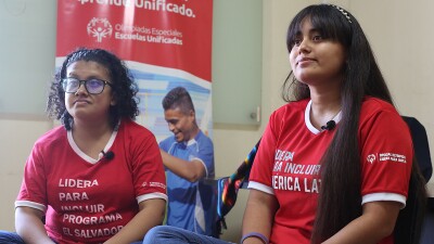 two girls in red shirts sitting next to each other