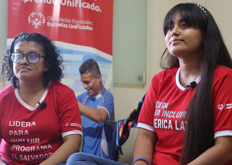 two girls in red shirts sitting next to each other