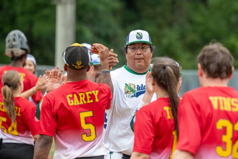 Special Olympics softball athletes and Unified partners high-five after a game. 