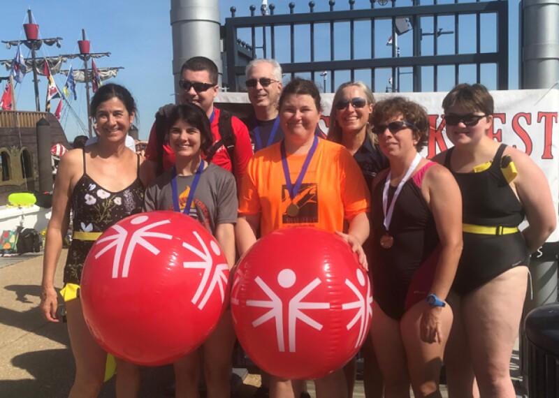 Special Olympics athletes and volunteers huddle together after athletes are awarded medals for their efforts. 