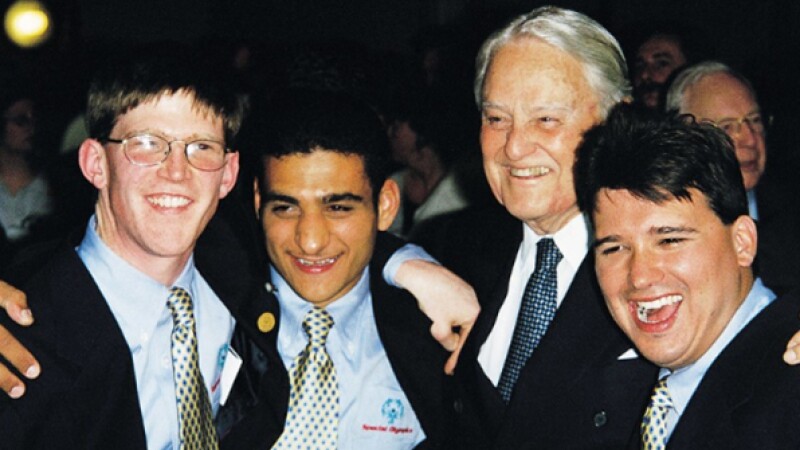 Thee young and one older man (Sargent Shriver) standing together smiling for a photo.