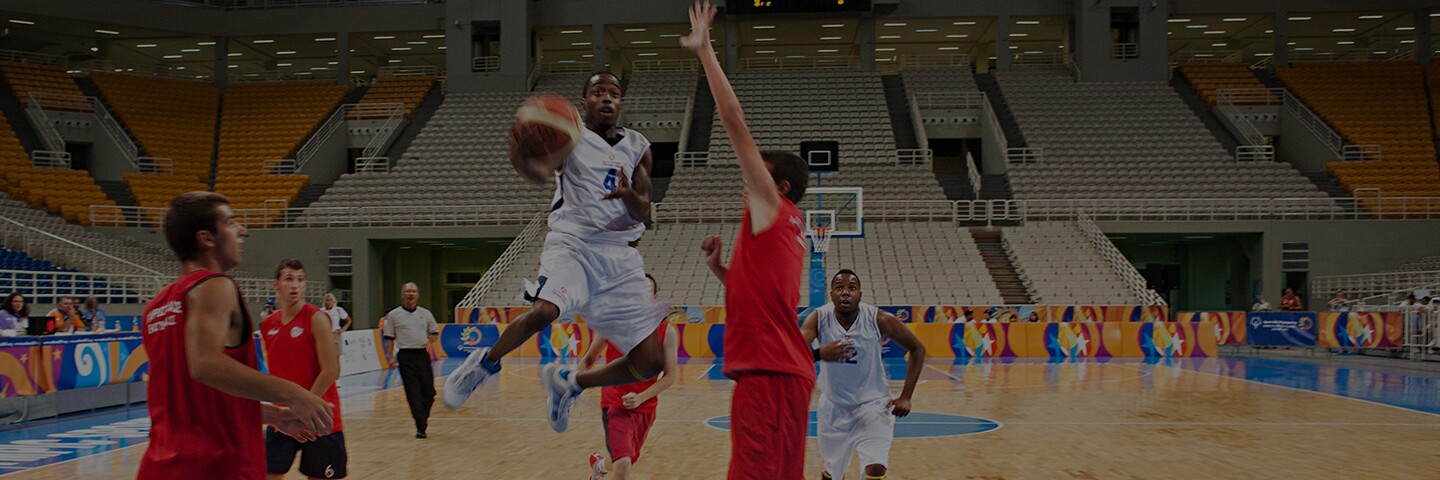 Athletes playing basketball on a court.