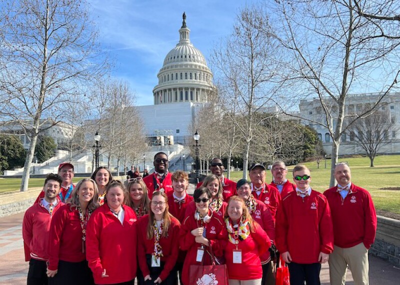 A group of Special Olympics athletes, Unified partners and staff members pose for a photo outside the US Capitol. 