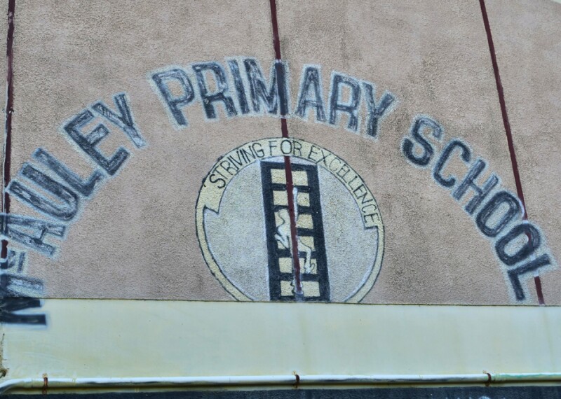 Image of McAuley Primary School name painted on a wall. 