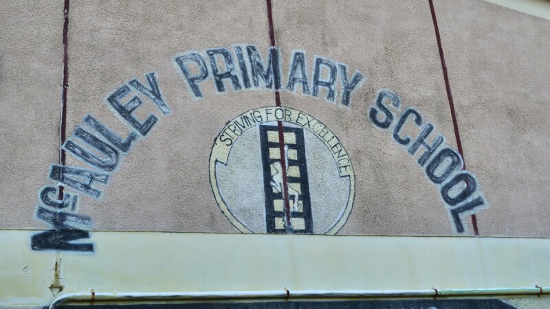 Image of McAuley Primary School name painted on a wall. 