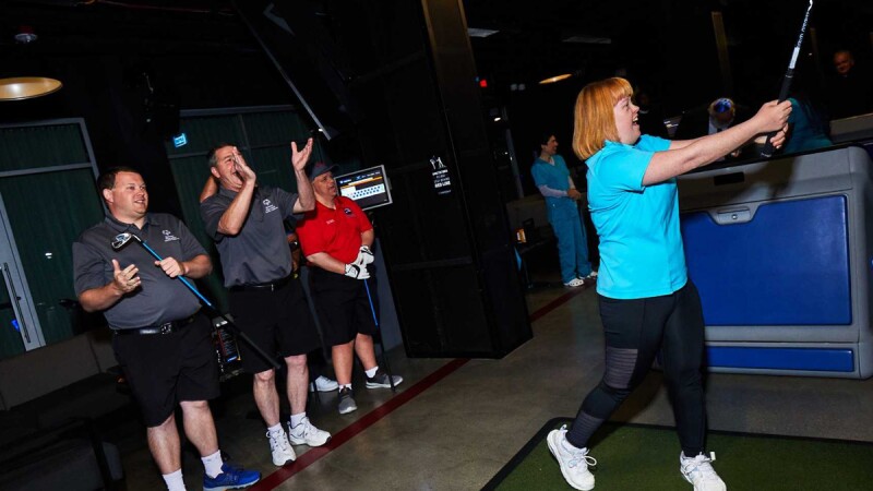 Woman hitting a ball with a golf club. 