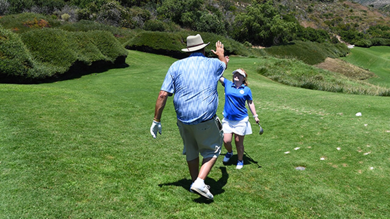 Amy high fives her triumph with celebrity golfer.