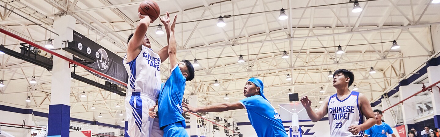 Five young men on the court playing basketball