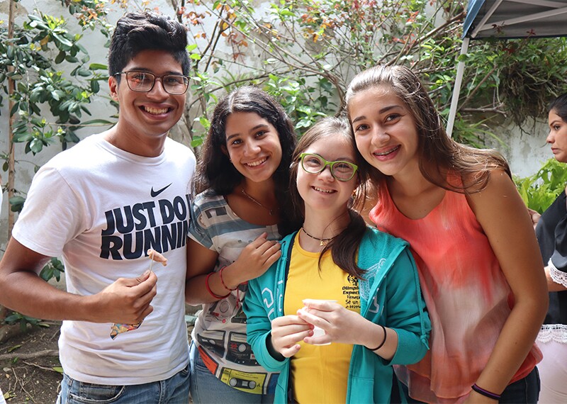 Four young adults standing together for a group photo. 