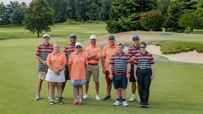 people standing in two rows on golf green