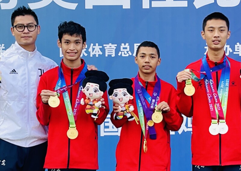 A coach with three athletes showing off their medals.