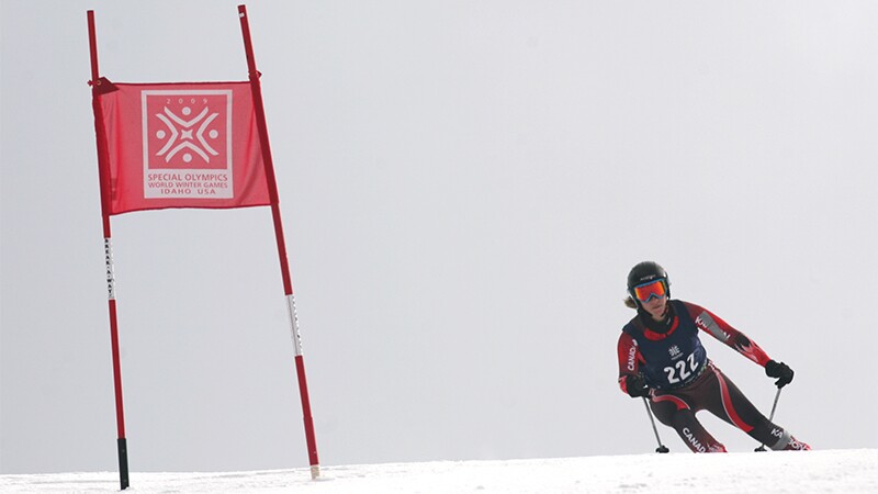 Skier going down the slope preparing to pass a flag. 