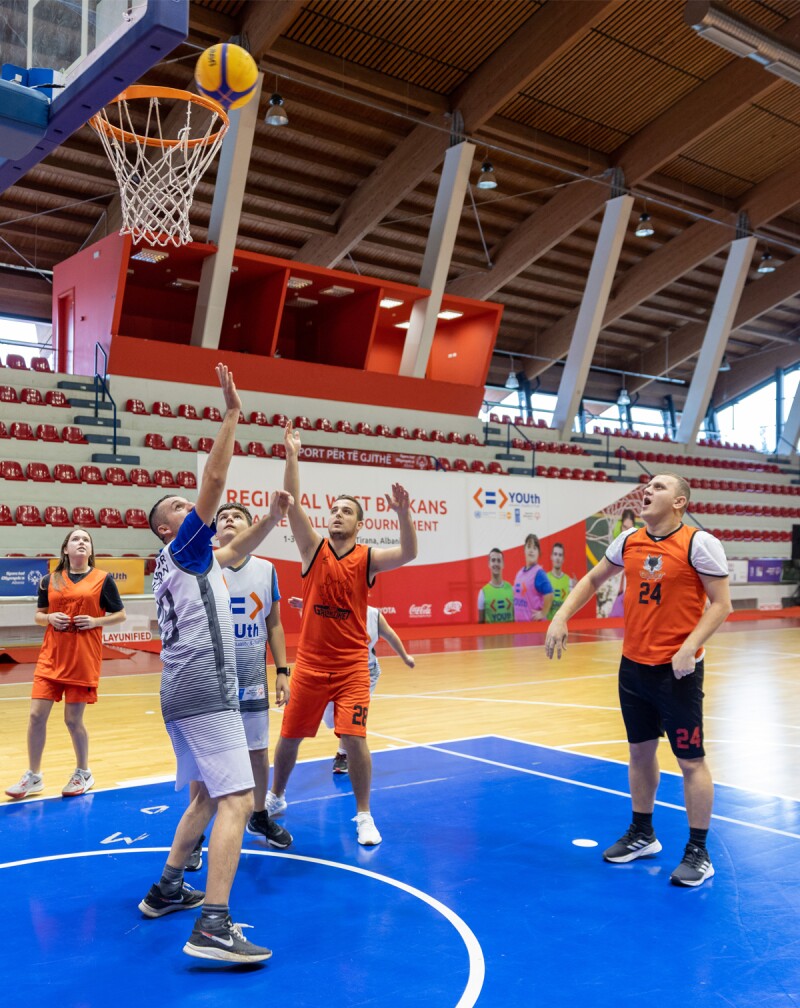 Six basketball players playing on a basketball court