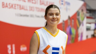 Young woman wearing a basketball jersey smiles