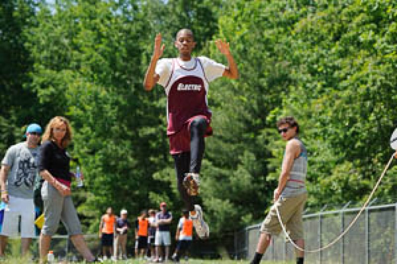 Volunteers watch and measure long jump distances.