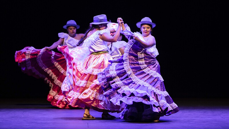 Dancers on stage with long flowing dresses