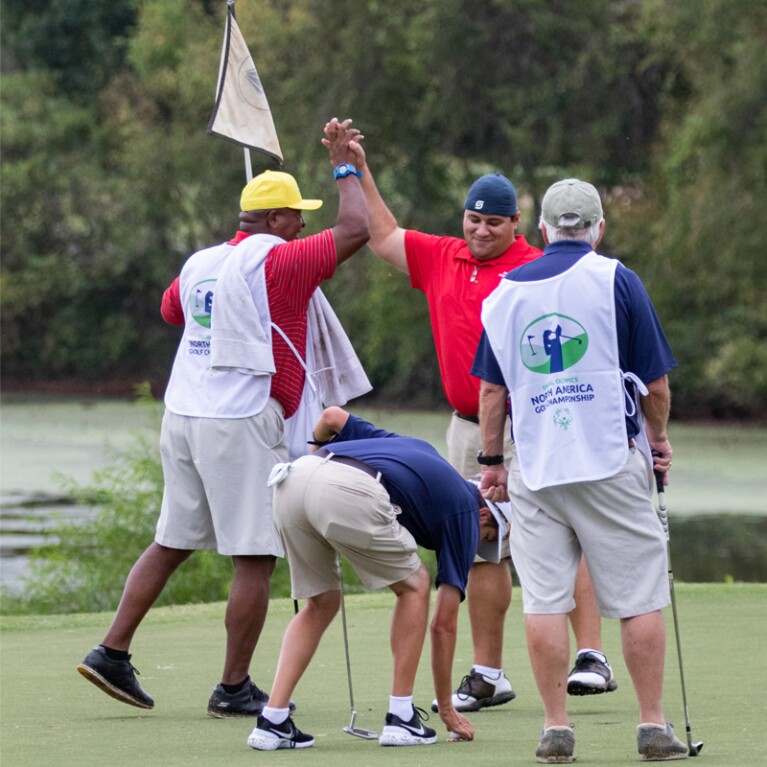 Golfers at the hole giving one another a high-5