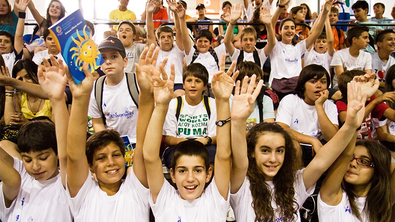 Young adults cheering in an auditorium. 