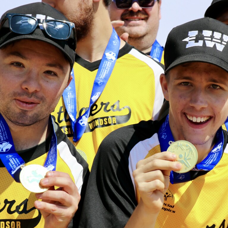 Two athletes showing off their medals. 