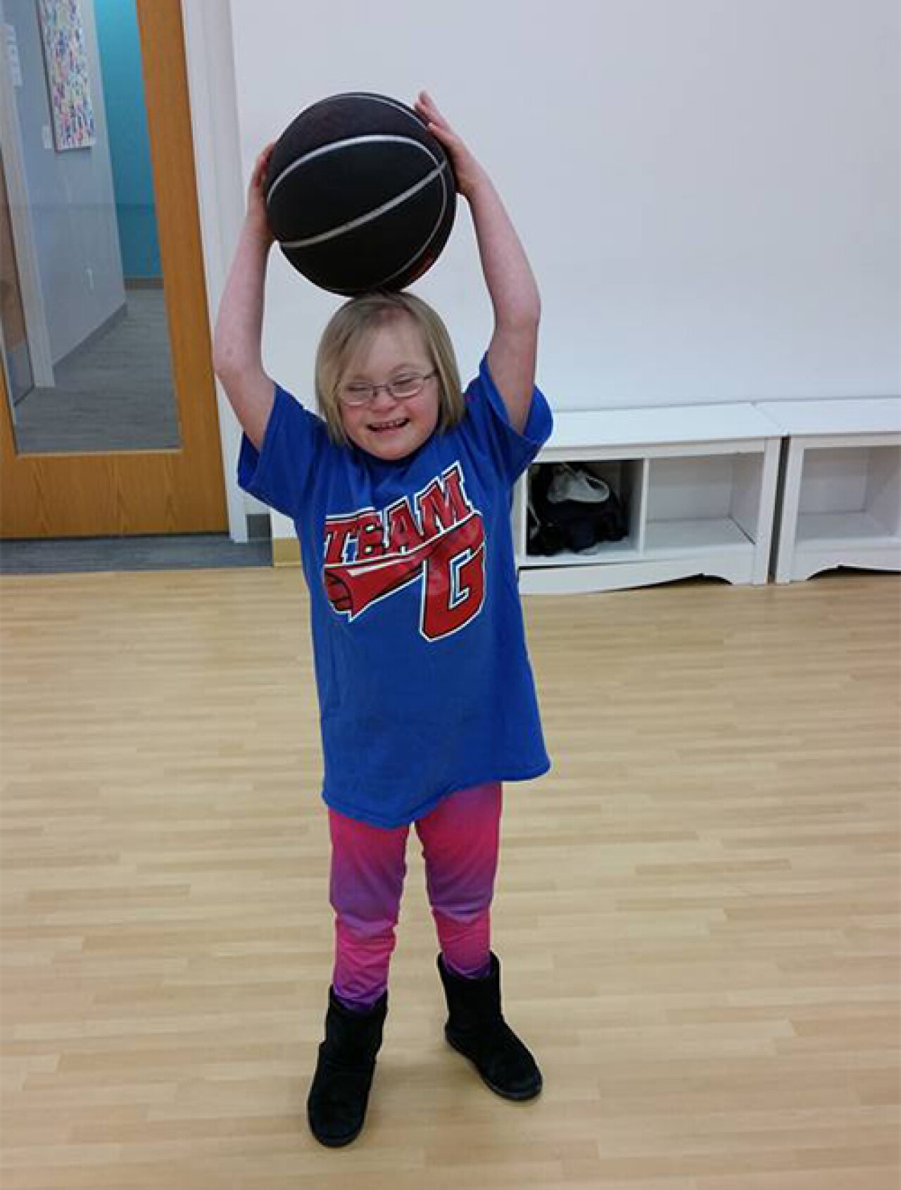 Violet holds a basketball on her head