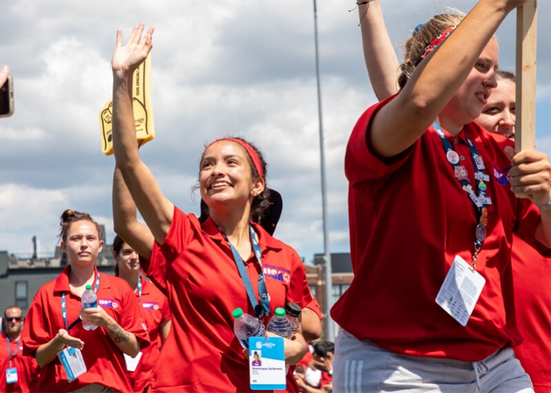 Athletes walking in a line and waving. 